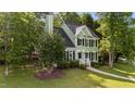 Charming two-story home with green siding, black shutters, and a well-manicured front yard at 3624 Singleleaf Ln, Raleigh, NC 27616