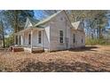Side view of single-story house with a covered porch and classic architecture, surrounded by trees at 404 Cherry St, Oxford, NC 27565