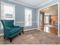 Inviting living room featuring neutral tones, a plush teal armchair, and natural light at 4617 Atterbury Ct, Raleigh, NC 27604