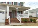 Inviting front porch with white railings, brick stairs, and manicured landscaping at 4821 Heathshire Dr, Raleigh, NC 27616