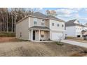 A beige two-story home featuring an attached garage and a small front yard at 538 E Waycliff Rd, Henderson, NC 27537