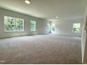 A light-filled bonus room with plush carpeting and multiple windows offering scenic views at 564 Jocund St # 11, Rolesville, NC 27571