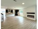 Spacious open-concept living room featuring modern fireplace and elegant wood floors, flowing into the gourmet kitchen at 564 Jocund St # 11, Rolesville, NC 27571