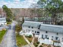 Aerial view of gray townhouses with white fences, manicured lawns, and mature trees at 7317 Sandy Creek Dr, Raleigh, NC 27615