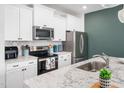 Modern kitchen with stainless appliances, granite countertops, and a subway tile backsplash at 7802 Flatrock Park Dr # 131, Knightdale, NC 27545