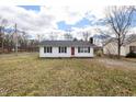 Cozy single-story home with black shutters, a red front door, and a tidy, green lawn at 825 Parkwood St, Burlington, NC 27215