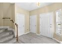 Bright entryway featuring hardwood floors, staircase, and ample closet space at 8310 Hempshire Pl # 106, Raleigh, NC 27613
