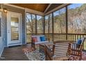 Cozy screened porch with wood furniture, a patterned rug, and a view of the wooded backyard at 8424 Brady Pointe Rd, Fuquay Varina, NC 27526