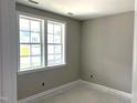 Bright bedroom featuring neutral walls, white trim, and double windows overlooking the yard at 9160 Dupree Meadow Dr # 13, Angier, NC 27501