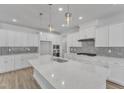 Bright white kitchen featuring a large center island, modern pendant lighting, and stainless steel appliances at 9168 Dupree Meadow Dr # 15, Angier, NC 27501