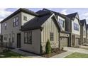 Attractive townhome featuring a stone facade, a gray garage door, and manicured lawns at 960 Double Helix Rd, Apex, NC 27523