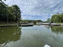 A view of the lake surrounded by trees and docks under a partly cloudy sky at 98 Beach Ln, Henderson, NC 27537