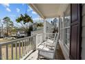 Cozy front porch featuring rocking chairs, hanging flowers, and a view of the neighborhood at 1007 Olde Midway Ct, Knightdale, NC 27545