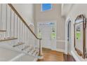 Bright foyer featuring hardwood floors, a staircase with white risers, and a transom window above the front door at 106 Legault Dr, Cary, NC 27513