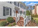 Inviting front porch with brick steps, white railing, and manicured landscaping, offering great curb appeal at 106 Legault Dr, Cary, NC 27513