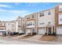 View of a row of multi-level townhomes with attached garages, manicured lawns, and welcoming curb appeal at 110 Darley Dale Loop, Apex, NC 27502