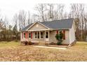 Single-story home showcasing tan siding, dark roof, and a cozy covered front porch at 12491 Buffalo Rd, Archer Lodge, NC 27527