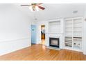 Bright living room with hardwood floors, fireplace, built-in shelving, and white walls at 12491 Buffalo Rd, Archer Lodge, NC 27527