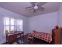 Cozy bedroom with natural light, hardwood floors, and ceiling fan above a colorful blanket at 1805 Shelton Ave, Durham, NC 27707