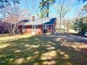 Large backyard with a deck and green space, surrounded by mature trees offering shade and privacy at 201 W Thorndale Dr, Oxford, NC 27565