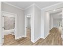 Bright hallway featuring wood-look flooring and white trim, leading to bathroom and bedrooms at 203 Jetson Creek Way, Youngsville, NC 27596