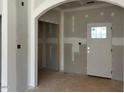 Bright living room featuring an arched doorway, unfinished drywall, and white trim at 28 Golden View Pl, Zebulon, NC 27597