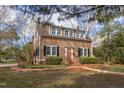 Beautiful exterior elevation of a two-story home, showcasing the lush landscaping and brick walkway at 300 Mccauley St, Chapel Hill, NC 27516