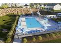 Aerial view of community pool with sun loungers and umbrellas surrounded by lush landscaping at 307 Chesapeake Commons St # 100, Garner, NC 27529