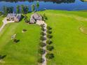 Aerial view of beautiful waterfront home with expansive lawn, mature trees, and private lake access at 309 Shoreline Dr, Princeton, NC 27569