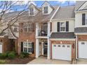 Charming brick townhouse featuring a one-car garage, small balcony, and inviting front entrance at 3124 Elm Tree Ln, Raleigh, NC 27614