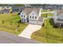 Aerial view of a two-story home with a three-car garage, large yard, and neighborhood setting at 350 Arlie Ln, Lillington, NC 27546
