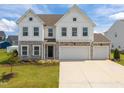 Charming two-story home featuring stone accents, white siding, a welcoming entrance, and manicured lawn at 350 Arlie Ln, Lillington, NC 27546