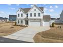 Two-story home with stone accents, three-car garage, and a curved driveway at 350 Arlie Ln, Lillington, NC 27546