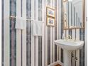 Classic powder room featuring a pedestal sink, vintage wallpaper, and gold accents creating a charming, timeless design at 3523 Elk St, Burlington, NC 27215