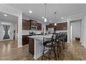 Modern kitchen featuring a large center island with granite countertops, stainless steel appliances, and stylish pendant lighting at 363 Grey Hawk Dr, Garner, NC 27529