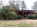 Rear exterior view of a home with a covered patio area and landscaping at 410 W Barrington St, Dunn, NC 28334