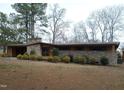 Front exterior view of a brick home with a covered carport and mature trees at 410 W Barrington St, Dunn, NC 28334