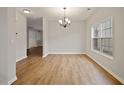 Charming dining room with modern chandelier and a window creating a warm and inviting ambiance at 4201 Hampstead Village Dr, Durham, NC 27703