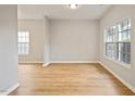 Inviting living room with large windows that illuminate the hardwood floors at 4201 Hampstead Village Dr, Durham, NC 27703
