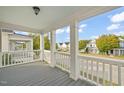Inviting porch view with white columns, railing, and wood flooring overlooking street at 7732 Acc Blvd, Raleigh, NC 27617