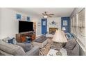 Charming living room with blue accent wall, brick fireplace, neutral paint, and a ceiling fan at 78 Eagle Rd, Coats, NC 27521