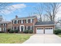 Classic brick home with mature landscaping and a driveway leading to a two-car garage at 810 Warwick Ct, Burlington, NC 27215