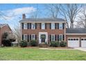 Beautiful brick home featuring black shutters, a green lawn, and a two car garage at 810 Warwick Ct, Burlington, NC 27215
