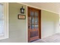Stylish front door with glass accents, complemented by a decorative address plaque and outdoor lighting at 8324 Humie Olive Rd, Apex, NC 27502