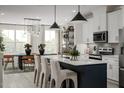 Modern kitchen featuring white cabinets, stainless steel appliances, and a dark blue island with marble countertops at 1005 Regalia Rd # 32, Durham, NC 27713