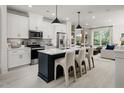 Modern kitchen with white cabinets, stainless steel appliances, a dark blue island and bar stool seating at 1005 Regalia Rd # 32, Durham, NC 27713