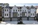 View of townhomes, featuring multi-story facades, individual garages, and modern architectural details at 1013 Regalia Rd # 28, Durham, NC 27713