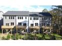 Exterior of townhomes featuring private wooden decks, sliding glass doors, and green lawn at 1013 Regalia Rd # 28, Durham, NC 27713