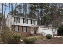 A charming two-story home with a brick and vinyl facade and mature trees on a well-manicured lawn at 1036 Whetstone Ct, Raleigh, NC 27615