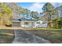 Single story home with a long concrete driveway, lush lawn and white painted brick at 109 Hardee St, Clayton, NC 27520